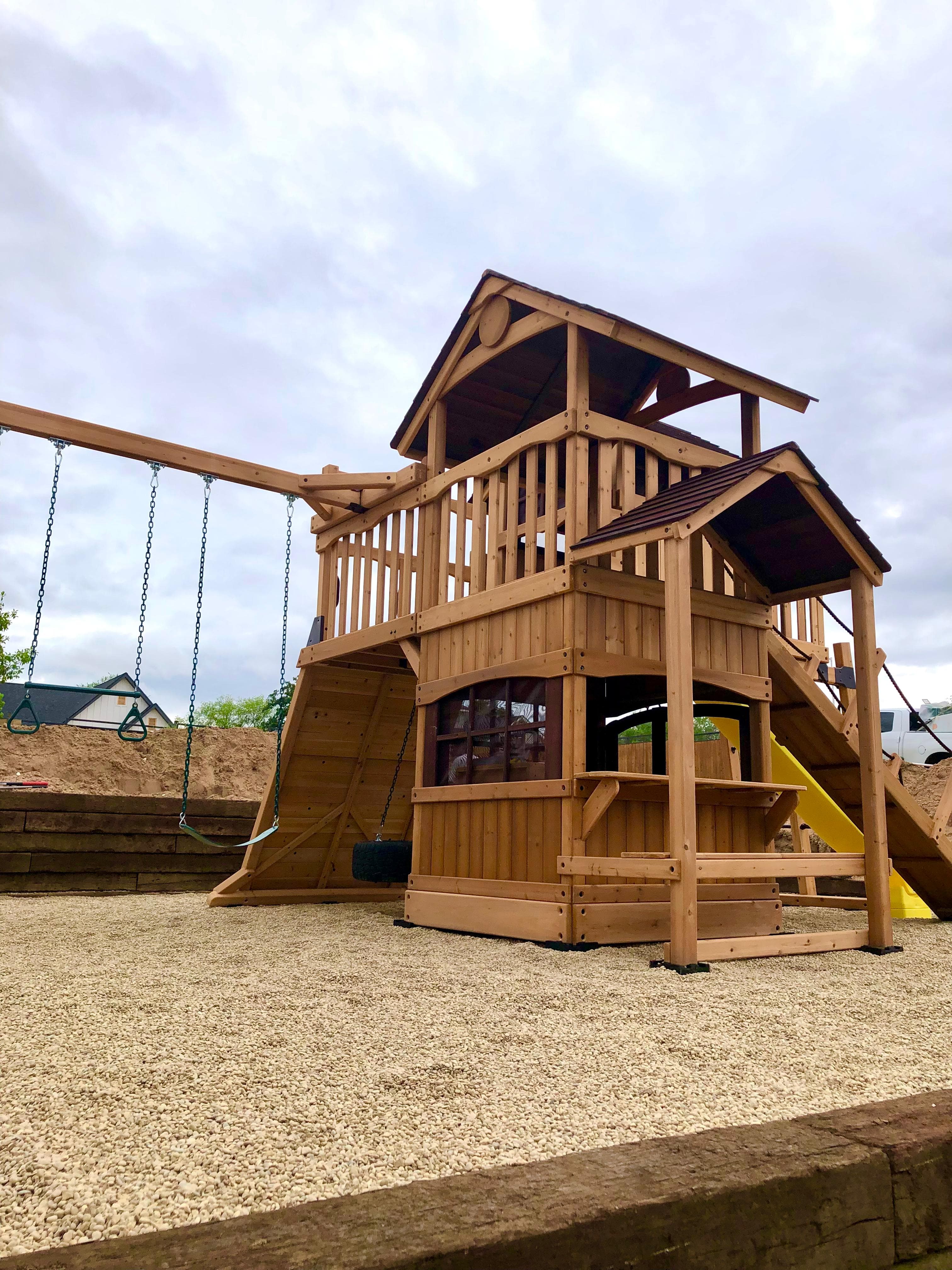 Backyard Adventures playset with gravel surfacing and clubhouse details.